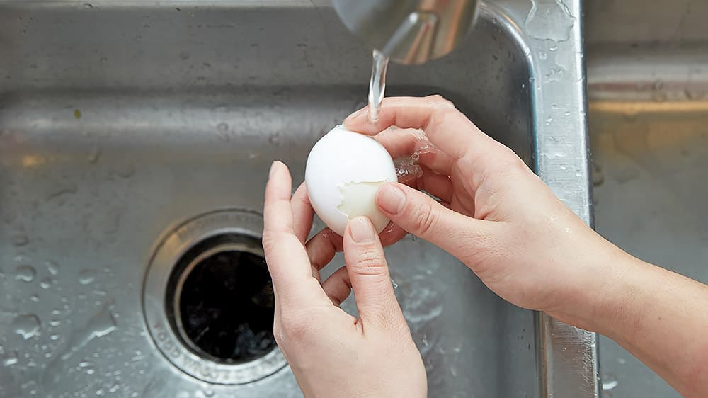 Peel egg under running water